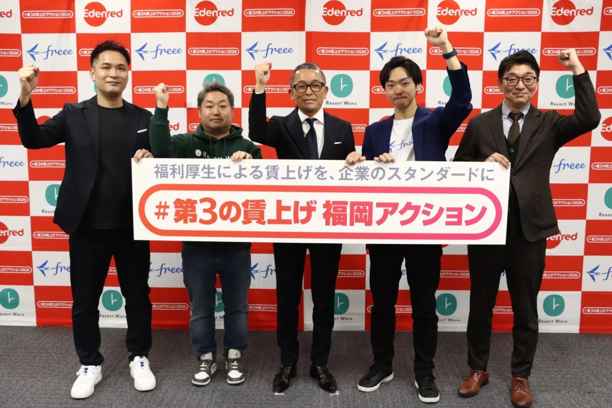 5人の男性が「#第3の賃上げ 福岡アクション」と書かれた横断幕を持ち、拳を上げてポーズをとっています。企業ロゴが散りばめられた背景の前でのイベント風景です。