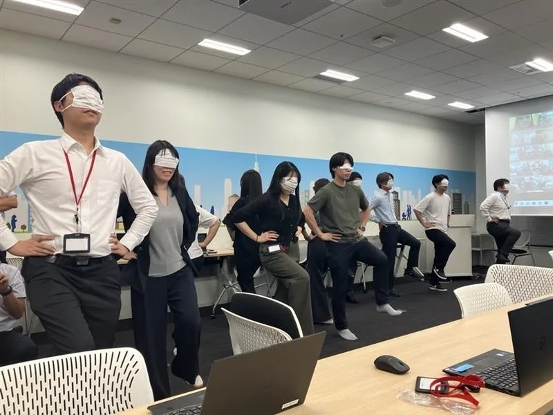 目隠しをしてバランス運動をする人々の写真