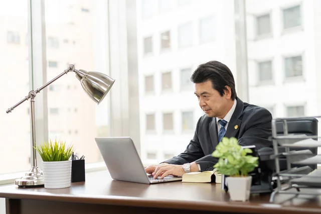 オフィスでノートパソコンに向かうビジネスマン