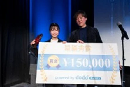 最優秀賞を受賞し、賞金パネルを持つ受賞者