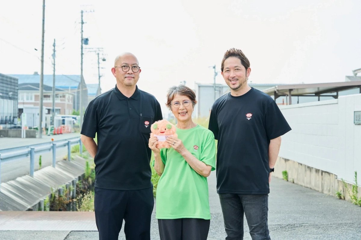 よしみんのぬいぐるみを持つ社員