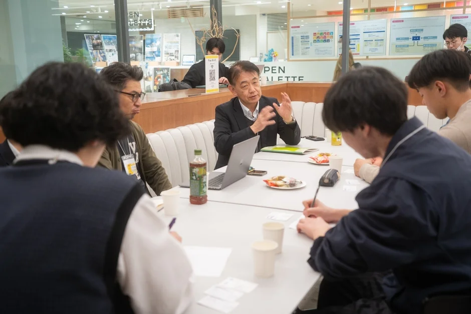 会議室で議論する若者たち