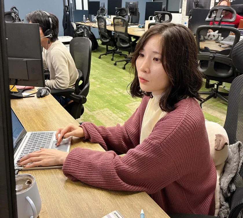 オフィスでノートパソコンを操作している女性の様子