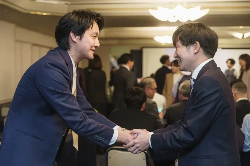 確かな成長を握手に込めて。仲間の成果を共に喜び合う。