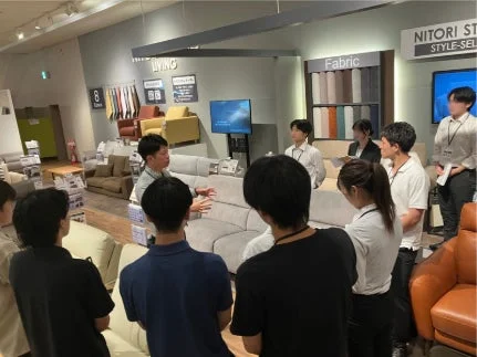 ニトリの店舗内で商品について説明を受けるメンバー