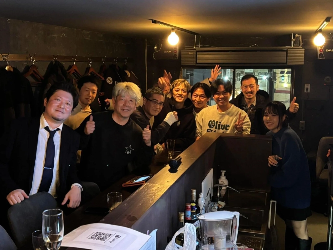 バーのカウンターで笑顔でポーズをとるグループ