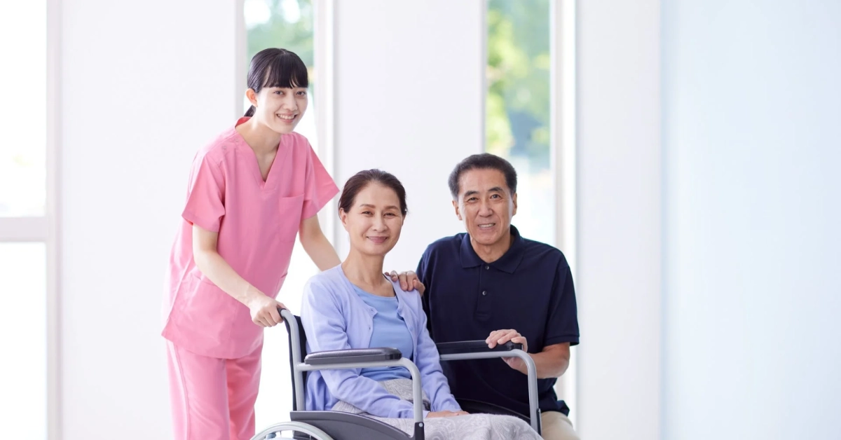 介護士が高齢者を優しく介助し、皆が笑顔の様子