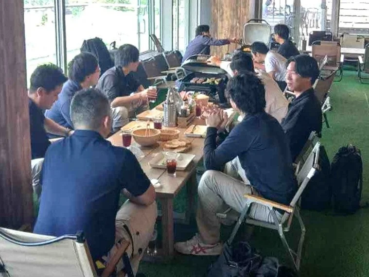 屋内のカジュアルな空間で食事を楽しむ男性グループ