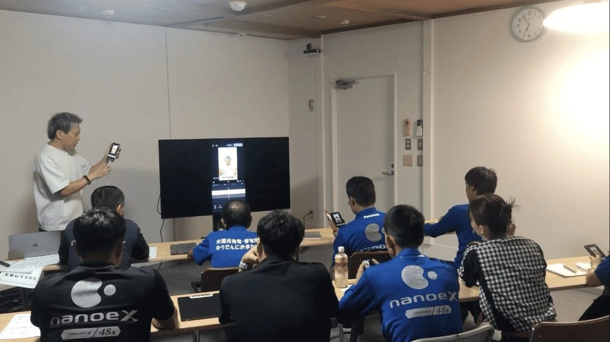 スマートフォンを使って説明する講師と、耳を傾ける参加者