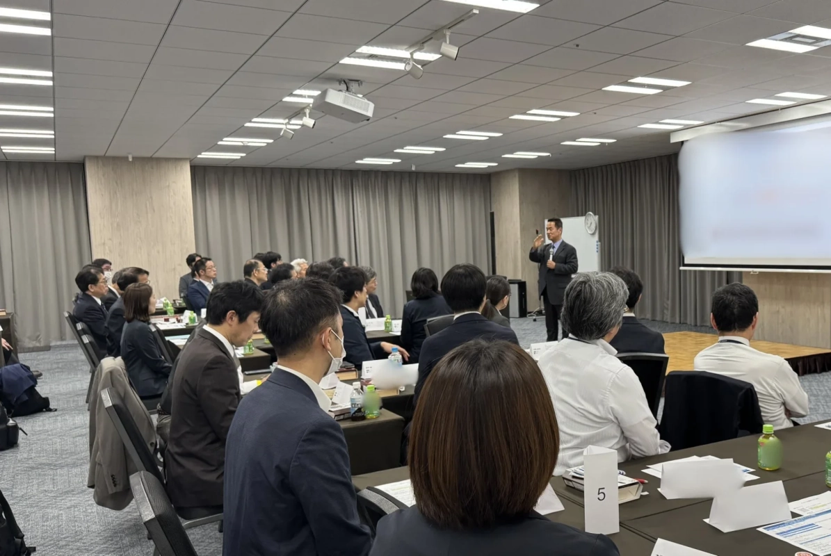 会議室でプレゼンテーションを聴講する参加者