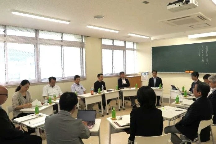 複数の大人がテーブルを囲んで議論する様子