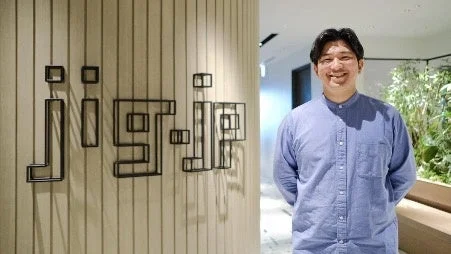 笑顔の男性とjig.jpのロゴ