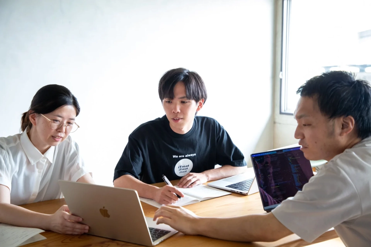 オフィスで共同作業をする3人の若者