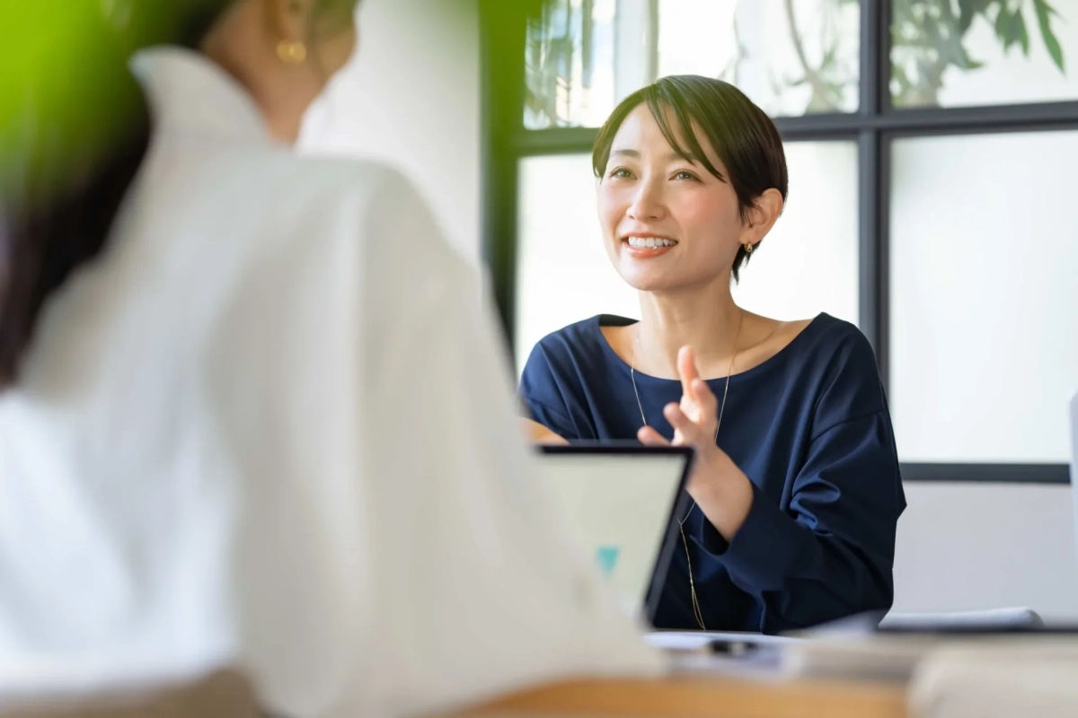 オフィスで二人の女性が会話している様子。