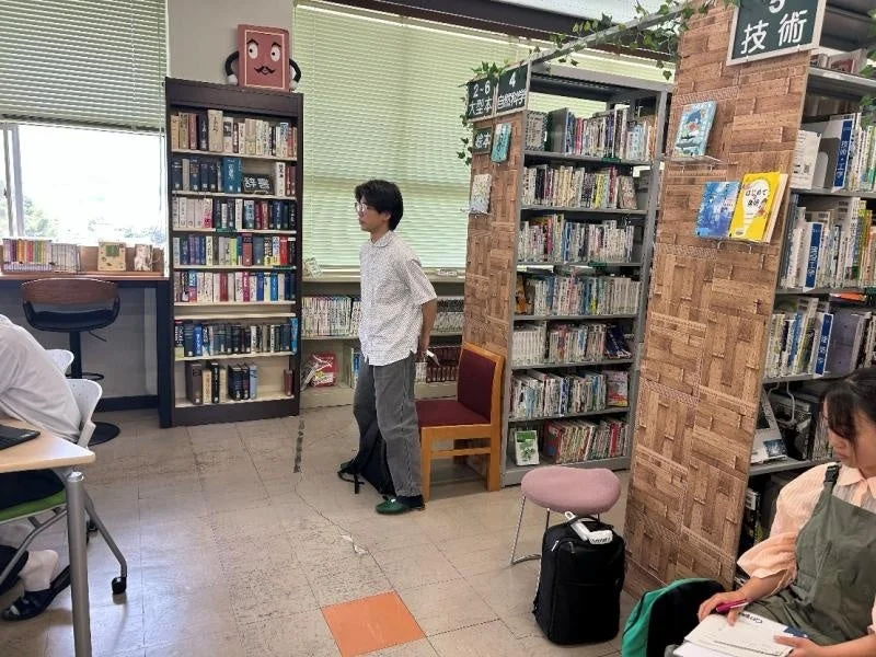 本棚に囲まれて学習する学生