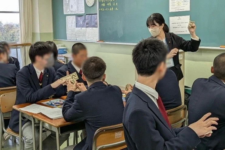 模擬紙幣のような教材で学習する生徒たち