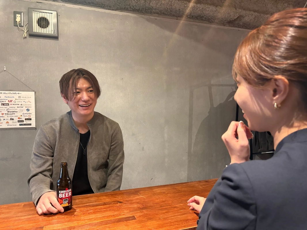 カウンターで談笑する男女とKOBUSHI BEER
