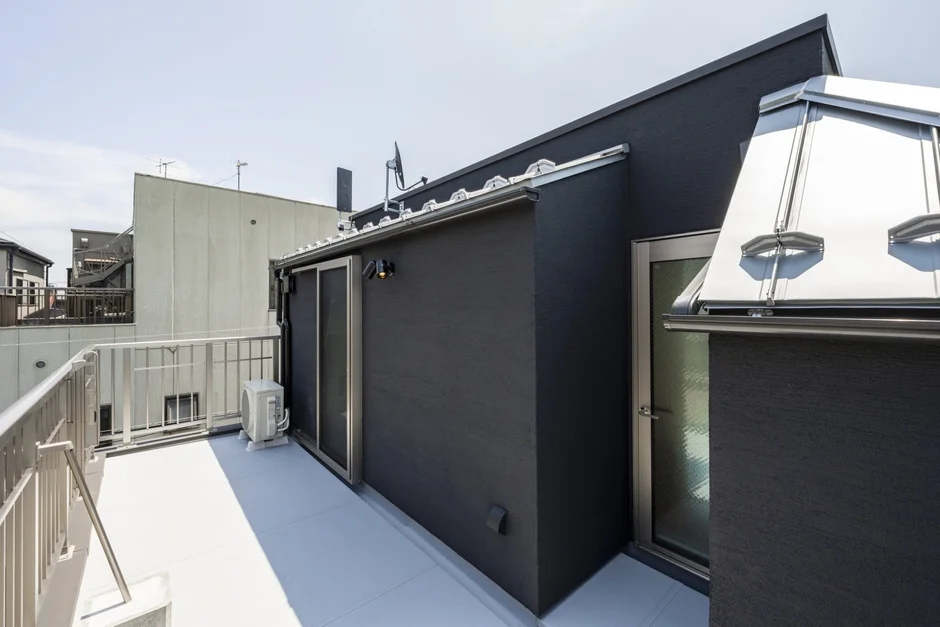 現代的な黒い外壁の建物の屋上バルコニー
