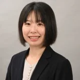 短髪の若いアジア人女性が笑顔でカメラを見つめているビジネスポートレート
