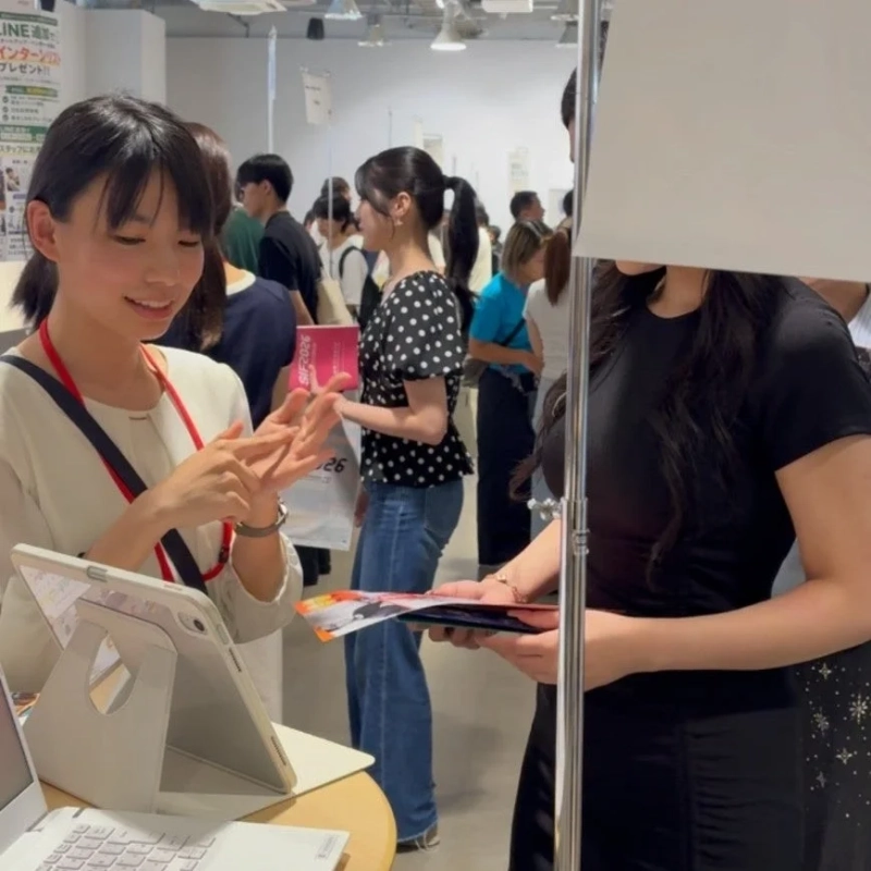 イベント会場で来場者と交流するインターン生