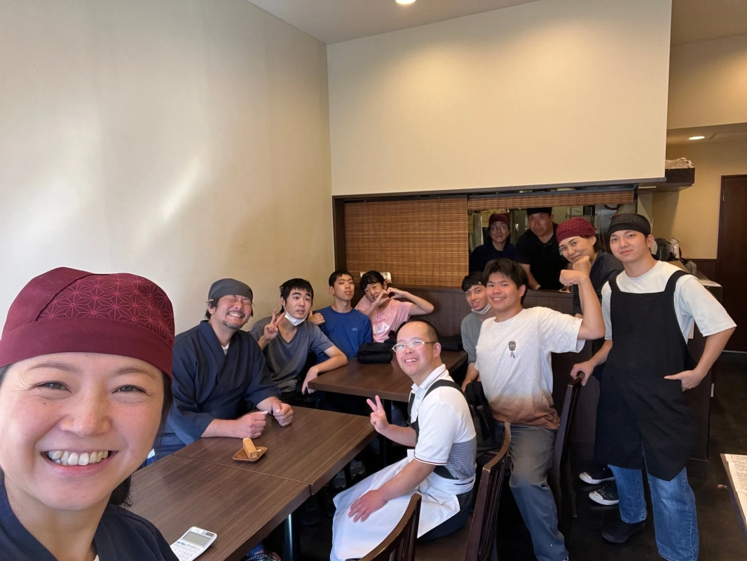 飲食店らしき場所で人々が笑顔の集合写真
