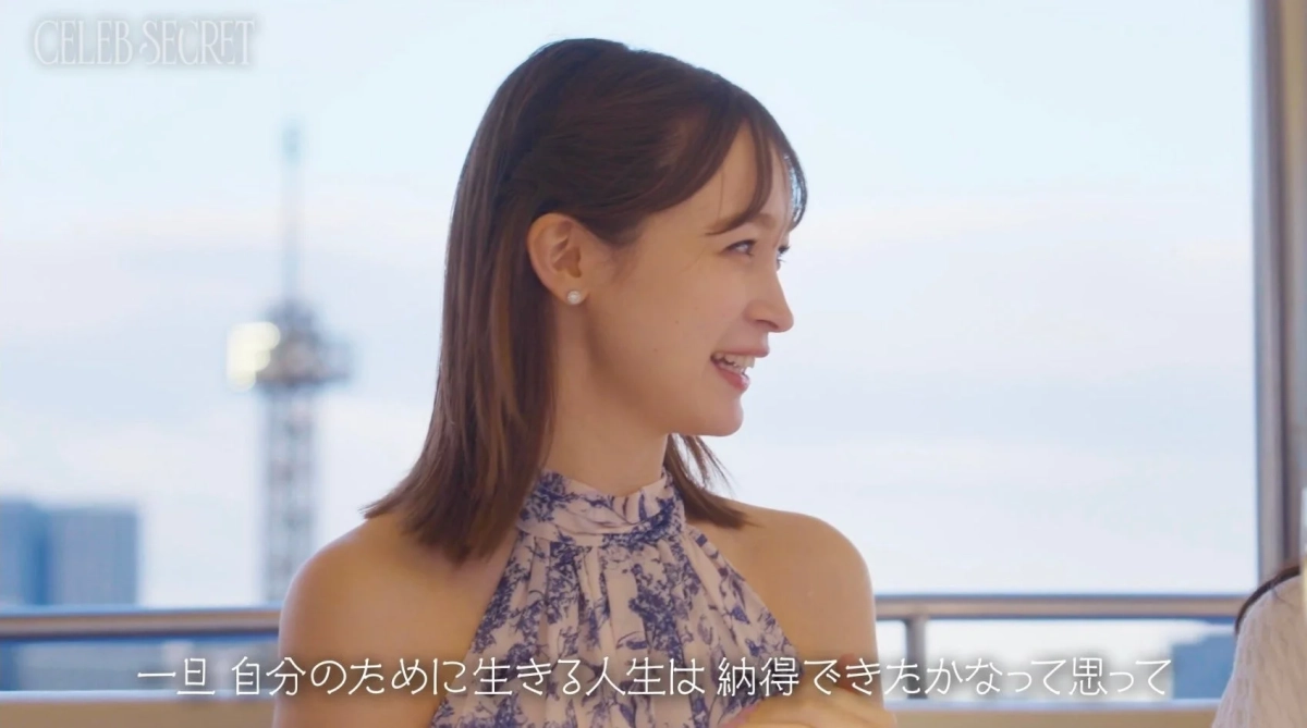 窓際に座り、笑顔で話す女性の横顔を捉えた画像