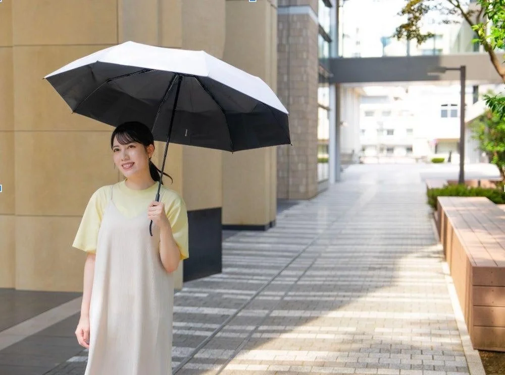 晴れた屋外で日傘を差して歩く女性