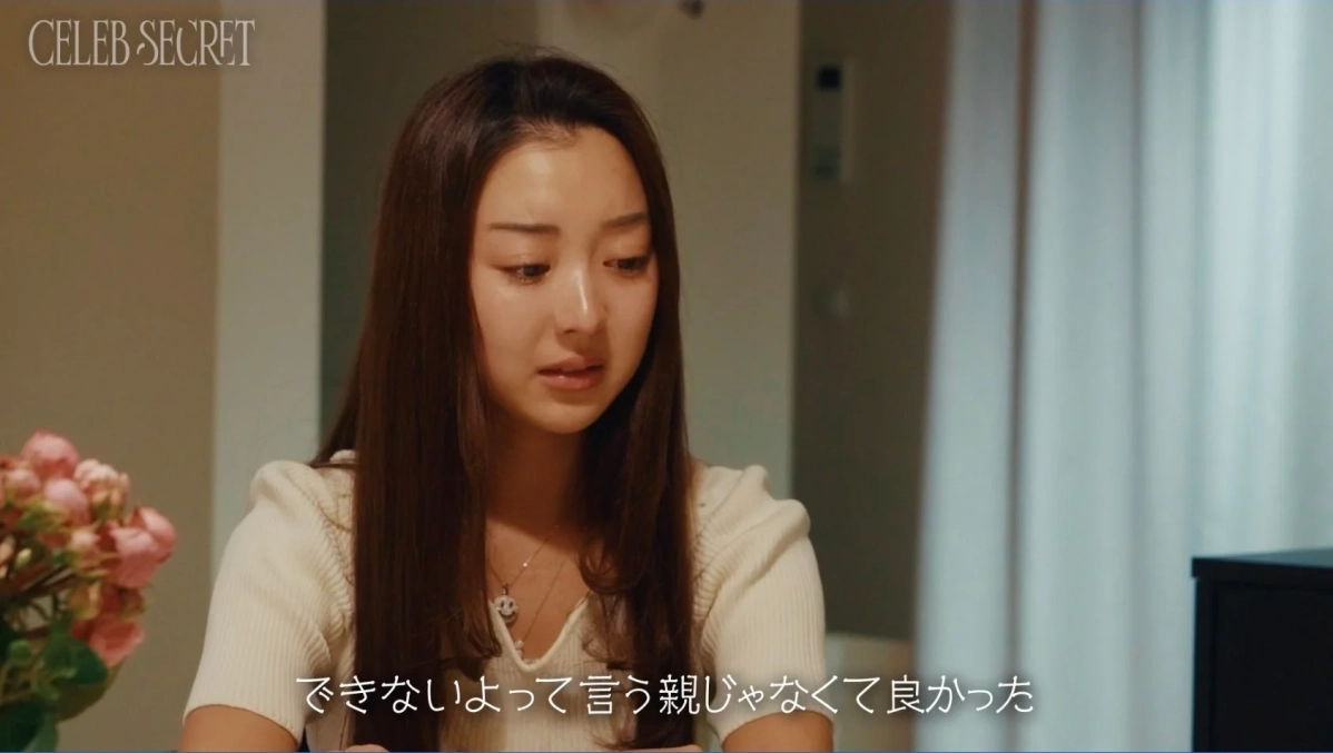 長髪の若い日本人女性が、悲しげな表情で下を向いている画像