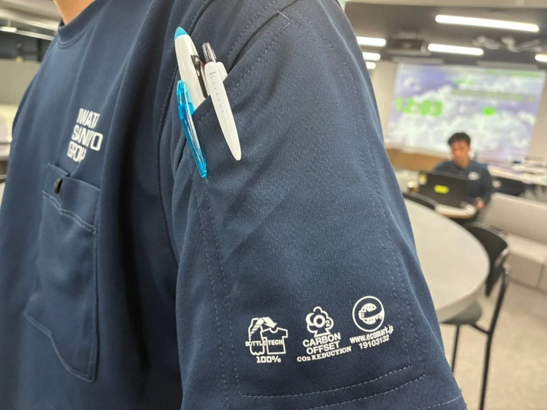 IWATA SANGYO GROUPのロゴと環境配慮に関するロゴが入ったTシャツの腕元