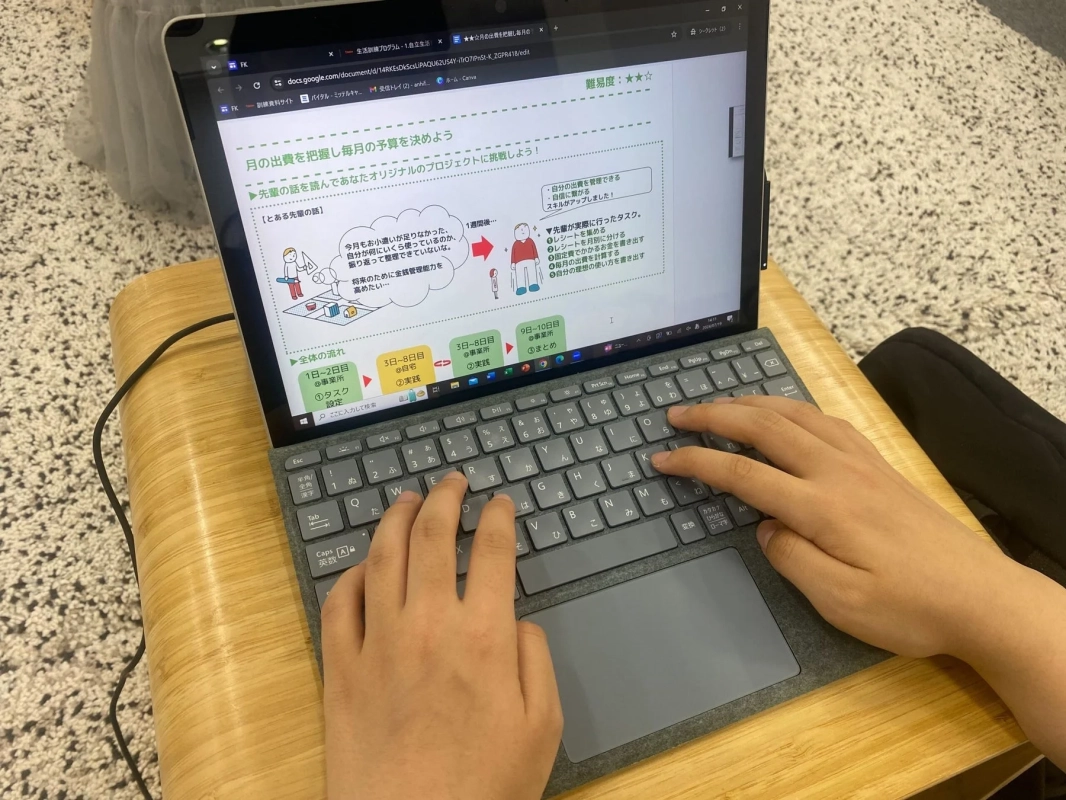 金銭管理の学習資料が表示されたノートパソコン