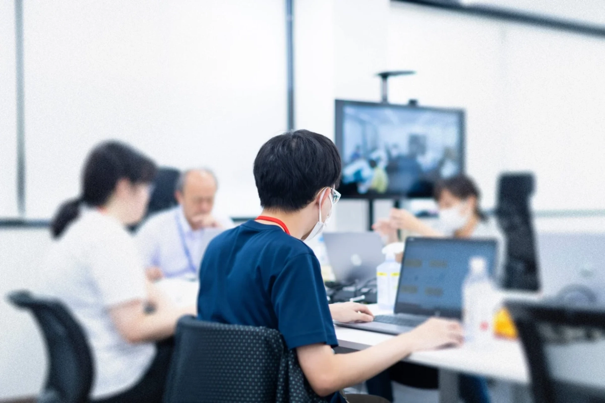 オフィスでラップトップに向かって作業する人々