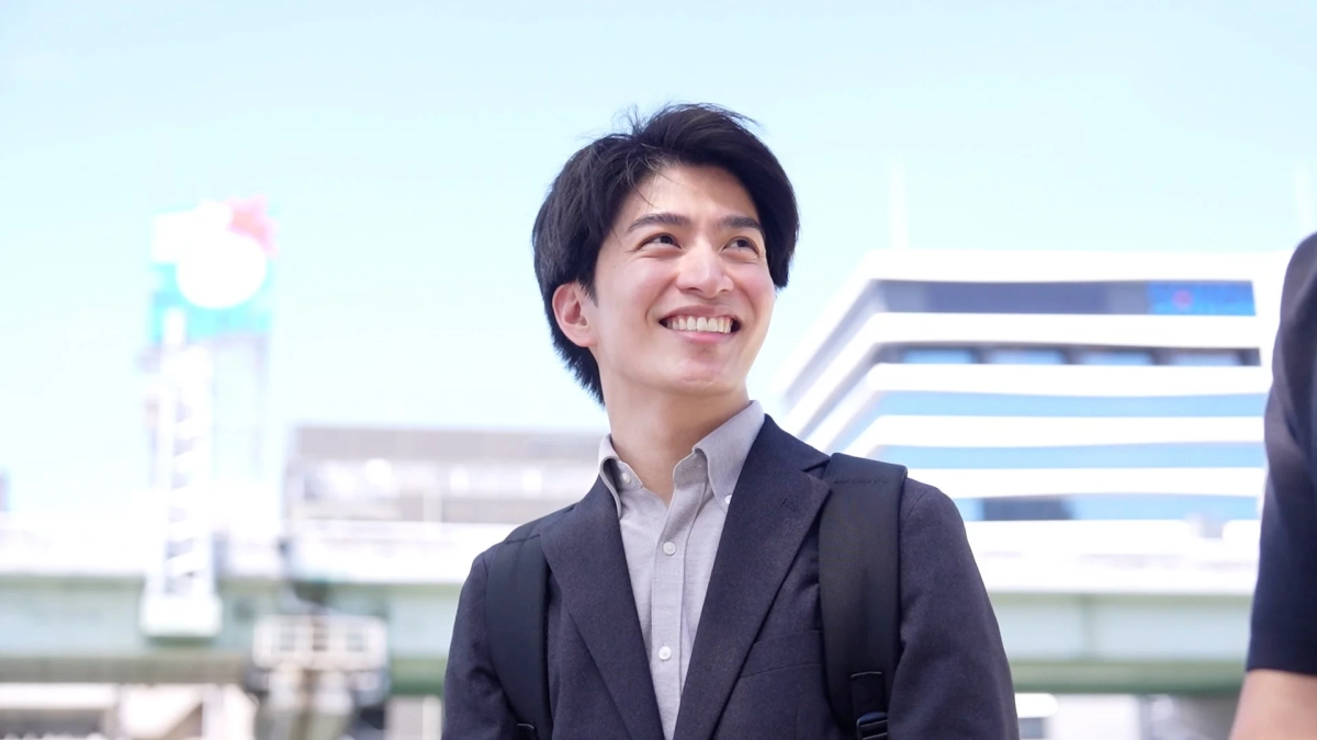 若い男性が満面の笑みを浮かべて空を見上げている様子