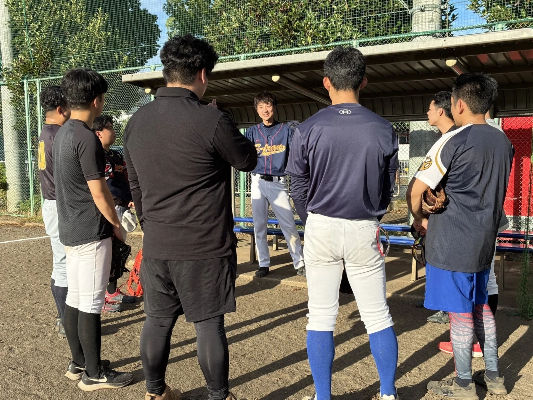 野球場でユニフォーム姿の男性が笑顔で話している様子