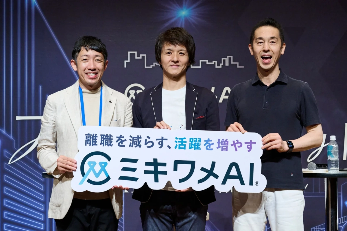 「離職を減らし活躍を増やす」というメッセージが書かれた「ミキワメAI」のボードを持つ3人の男性が笑顔で並んでいる。企業イベントでの発表やプロモーションの場面を捉えた一枚。